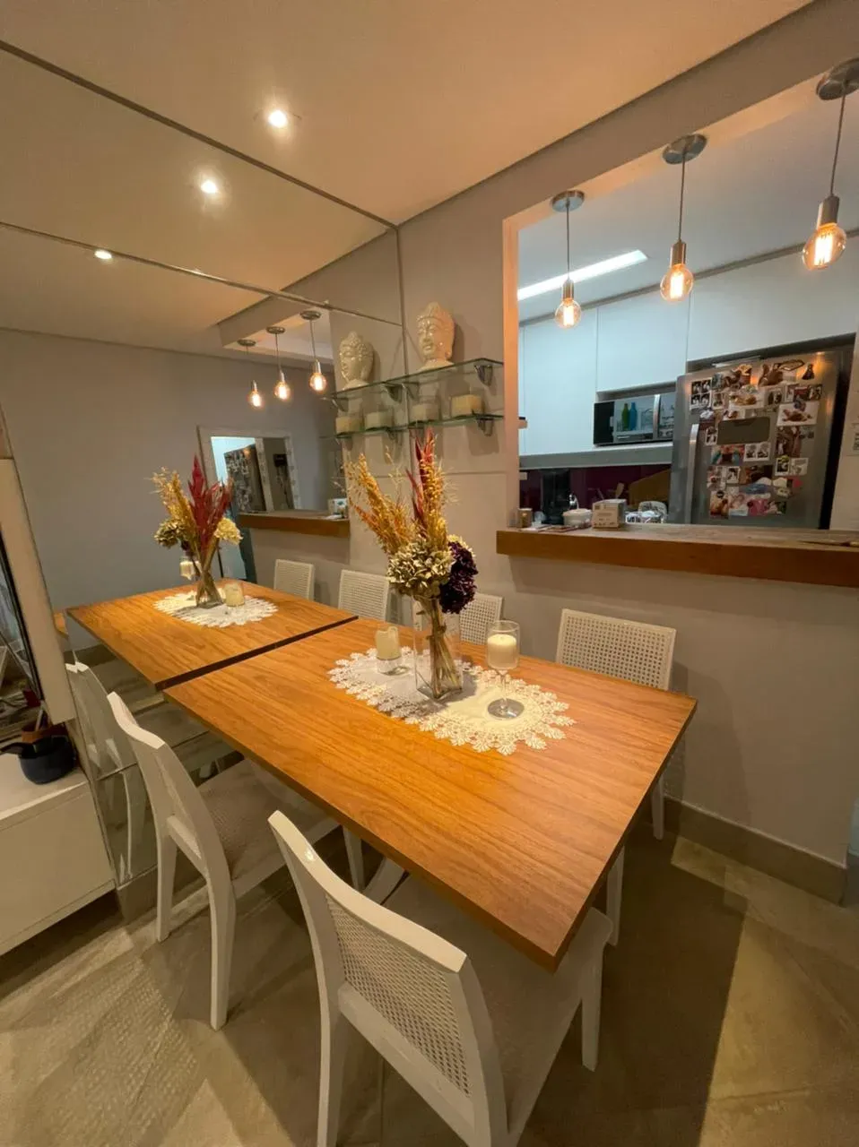 Sala de jantar integrada à cozinha, com mesa de madeira e marcenaria sob medida